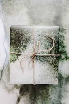 a gift wrapped in brown paper and tied with twine, on a marble background