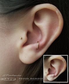 a close up of a person's ear with an ear piercing in the middle