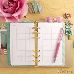 an open planner with a pink flower on top