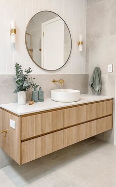 a bathroom with two sinks and a large round mirror above the sink on the wall