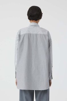 This striped shirt blouse is made of soft cotton fabric – woven in portugal and 100% made of organic cotton. it comes with patchwork details chest pockets side slits and pearl buttons. slightly longer in the back.    - relaxed fit  - back length: 30.9” (size s)  - model (5'11'') wears size s  - made in portugal Striped Cotton Shirt For Work, Cotton Shirt With Vertical Stripes For Fall, Fall Cotton Shirt With Vertical Stripes, Striped Collar Shirttail Hem Top, Relaxed Fit Blouse With Striped Collar For Work, Cotton Button-up Tops With Vertical Stripes, Oversized Top With Striped Collar For Work, Cotton Tops With Vertical Stripes For Fall, Cotton Shirt With Vertical Stripes For Daywear