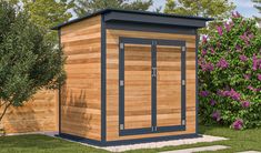 a small wooden outhouse sitting in the grass