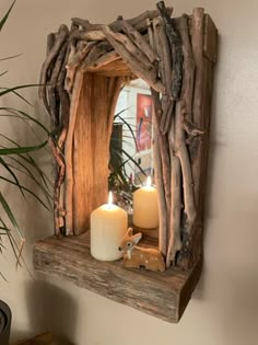 a mirror made out of driftwood with two candles