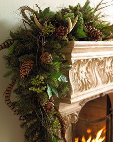 a fireplace decorated with greenery and pine cones