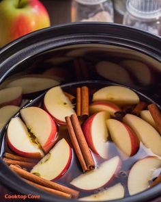 apples and cinnamon sticks are in an apple cider