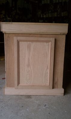 an unfinished wooden cabinet sitting on top of a floor