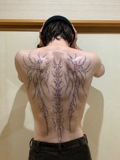 the back of a man with tattoos on his body