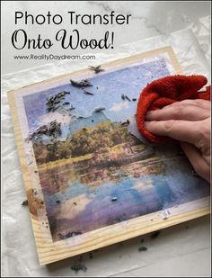 someone is holding up an old photo to show it's reflection in the water