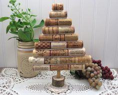 a small tree made out of wine corks on top of a doily next to a potted plant