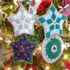 three crocheted ornaments hanging from a christmas tree