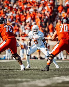 a football player is getting ready to kick the ball while others watch from the sidelines