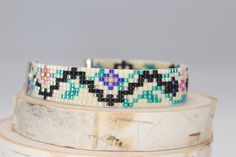 two bracelets are stacked on top of each other, one has black and white beads