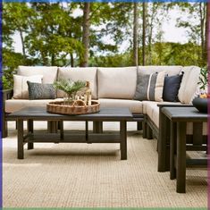 a couch and table on a patio with trees in the backgroung area