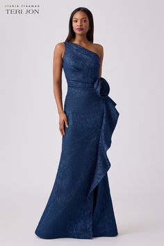 a woman in a blue evening gown with an asymmetrical bow on the waist