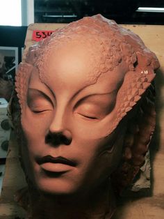 a clay sculpture of a woman's head with her eyes closed