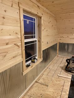 the inside of a wooden cabin with tools on the floor and windows in the wall