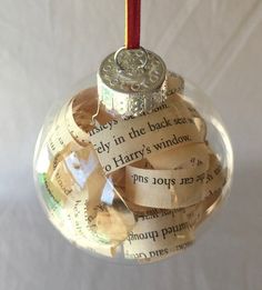 a glass ornament filled with words and a red candle sticking out of it