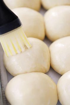 a close up of a brush on some doughnuts in the process of being cooked