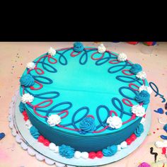 a blue cake with red, white and blue icing on it sitting on a table