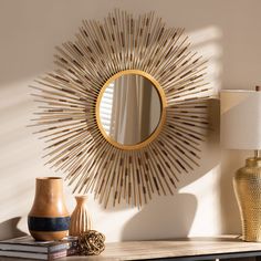 a table with a mirror and vases on it next to a wall mounted lamp