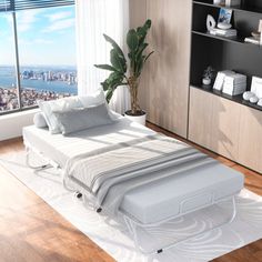 a bed sitting on top of a hard wood floor next to a window with a city view