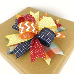 a gift wrapped in brown paper with a colorful bow