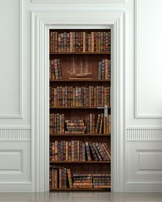 an open bookcase with many books on it in a room that has white walls