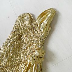 a gold dress is laying on the floor