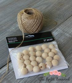 some balls of yarn sitting on top of a wooden table next to a ball of twine