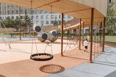 an empty playground with swings and balls on the ground