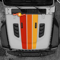 the front end of a truck with an orange and yellow stripe painted on it