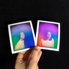 two polaroid photos being held up in front of a black background, with one person's hand holding the other