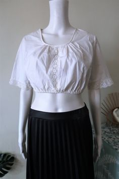 Beautiful Austrian Vintage crop blouse from the 1990s. Comfortable white cotton fabric. Pull on style. Wide short sleeves with crochet lace. Elasticated waist. Scoop neck and crochet lace insert on the front. Looks great in combination with a pair of highwaist jeans. BRAND: No brand label anymore ERA: 1990s COLOR: White Fabric: 100% cotton SIZE: Vintage size 42, fits best a modern size M to small L - please check the measurements for reference MEASUREMENTS: Pit to pit 46cm (with some additional Fitted Cotton Lace Top With Broderie Anglaise, Summer Cropped Tops With Lace Collar, Cropped Tops With Lace Collar For Summer, White Broderie Anglaise Lace Top With Short Sleeves, Fitted Cotton Lace Tops With Crochet Trim, Vintage White Short Sleeve Crop Top, Fitted Cropped Top With Lace Collar, Short Sleeve Cotton Lace Top With Crochet Trim, Summer Short Sleeve Crop Top With Lace Trim