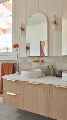 a bathroom with two sinks and mirrors on the wall