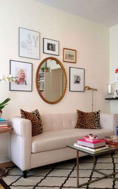 a living room filled with furniture and framed pictures on the wall above a coffee table