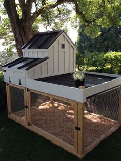 a chicken coop in the middle of some grass