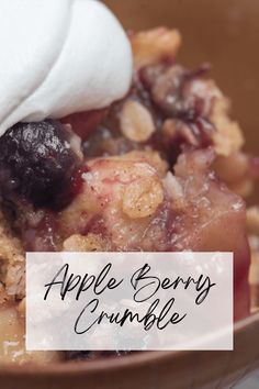 an apple berry crumble in a bowl with whipped cream on top and the words, apple berry crumble above it