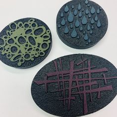 three circular coasters with designs on them