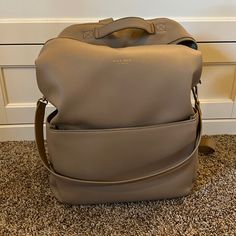 This Diaper Bag Was An Absolute Dream. So Many Pockets, Plenty Of Space And You Can Wear It As A Backpack Or On The Shoulder. It Is Used But Still In Great Condition! There Is Some Slight Cracking On The Top Handle Which I Included A Picture Of. It’s In The Color Sand. Luxury Large Capacity Backpack For Errands, Leather Backpack With Large Capacity For Errands, Leather Large Capacity Backpack For Errands, Chic Tote Backpack With Detachable Strap, Versatile Large Capacity Backpack For Errands, Large Capacity Leather Satchel Backpack For Errands, Large Capacity Leather Backpack For Errands, Elegant Large Capacity Everyday Backpack, Luxury Everyday Rectangular Backpack