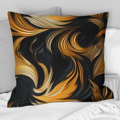 a black, yellow and white pillow on top of a bed next to a throw pillow