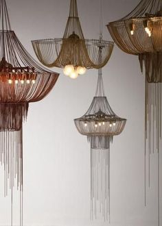 a group of chandeliers hanging from the ceiling in a room with white walls