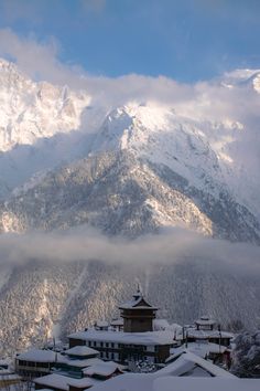 the mountains are covered in snow and clouds