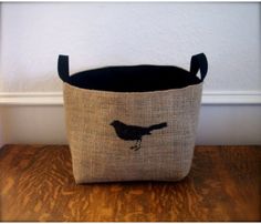 a black and white bird on a burlocked fabric storage bin with handles