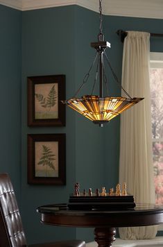 a chandelier hanging over a table in a room with blue walls and chairs