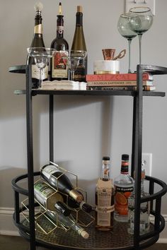 a bar cart filled with liquor bottles and wine glasses