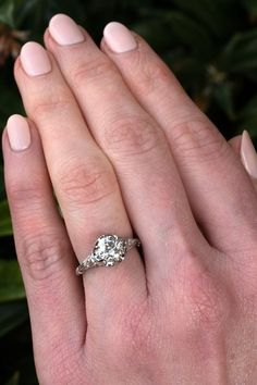 a woman's hand with a diamond ring on her finger and the other hand holding an engagement ring