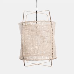 a white light hanging from a wire with a beige fabric covering on it's side