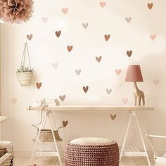 a white room with hearts on the wall and a pink flower hanging from the ceiling