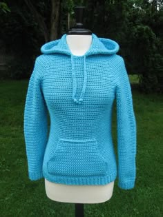 a blue sweater on a mannequin in the grass