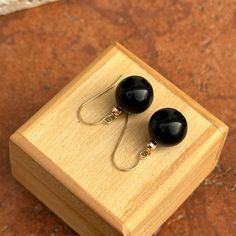 14KT yellow gold ear wire earrings with genuine black onyx ball/bead. Earrings measure: 22mm (length) x 11.50 (width) Hoops weight: 3 grams Stamped on wire Classic Black Dangle Jewelry, Classic Black Drop Earrings, Adjustable Black Jewelry With Ear Wire, Black Adjustable Jewelry With Ear Wire, Black Minimalist Jewelry With Ear Wire, Black Drop Earrings With French Hook, Elegant Black French Hook Earrings, Classic Onyx Round Beads Jewelry, Classic Onyx Round Bead Jewelry